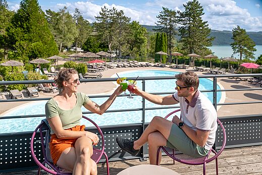 Piscina exterior, pareja con cócteles en camping CLICOCHIC Trelachaume Maisod (39).