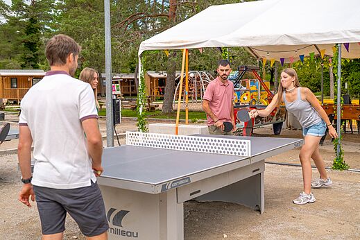 Animado partido de ping-pong en mesa Cornilleau en el camping CLICOCHIC Trelachaume en Maisod (39).