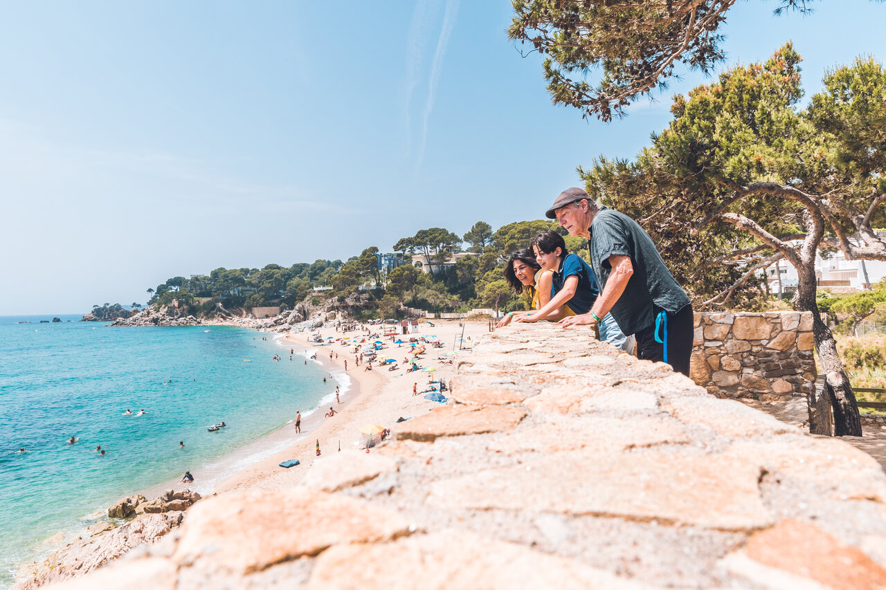 Familia admirando la playa de arena fina y el mar turquesa en el camping CAPFUN Treumal en Platja d'Aro (17).