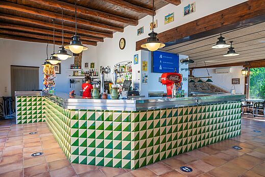 Bar con barra de azulejos verdes y blancos en el camping CAPFUN Treumal.