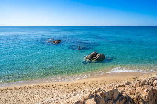 Playa de arena, aguas turquesas, paddleboard en el camping CAPFUN Treumal en Platja d'Aro (17).