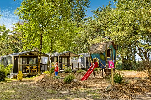 Zona de juegos infantil con tobogán y Mobil-homes en camping CLICOCHIC Trois Chênes Pornichet (44).