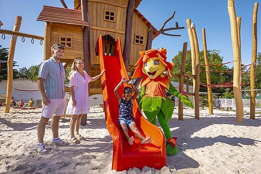 Zona de juegos con tobogán, niño y mascota en el camping CLICOCHIC Trois Chênes.