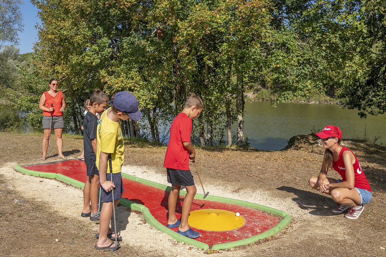 Ni�os jugando minigolf cerca del lago en camping CAPFUN Ullule Tournon d'Agenais.