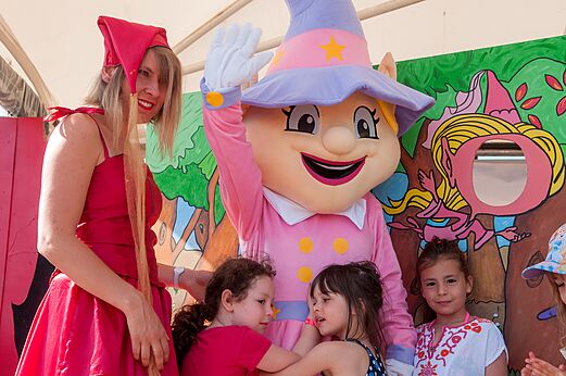 Mascota y animadora con niños durante una actividad en el camping CAPFUN Ullule en Tournon d'Agenais (47).