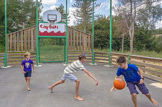 Niños jugando baloncesto en la cancha multideporte del camping CAPFUN Ullule en Tournon d'Agenais (47).