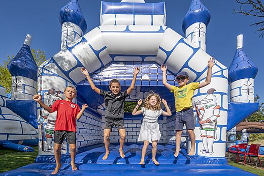 Niños saltando en un castillo hinchable azul y blanco en el camping CAPFUN Ullule en Tournon d'Agenais (47).