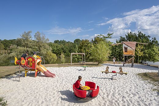 Zona de juegos de arena con tobogán, columpios y juegos infantiles en el camping CAPFUN Ullule en Tournon d'Agenais (47).