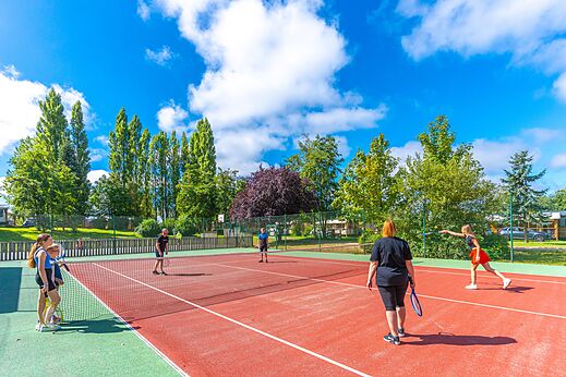 Cancha de tenis con jugadores en el camping CAPFUN Val d'Authie en Villers sur Authie (80).