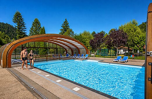 Piscina cubierta/descubierta con sillas en el camping CLICOCHIC Verte Vall�e en XONRUPT LONGEMER (88).