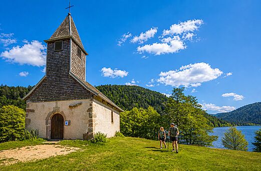 Capilla, excursionistas y lago de monta�a en camping CLICOCHIC Verte Vall�e XONRUPT LONGEMER.
