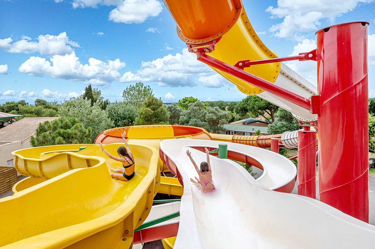 Dos ni�os en toboganes acu�ticos coloridos en el camping CAPFUN Vignes d'Or en Serignan.
