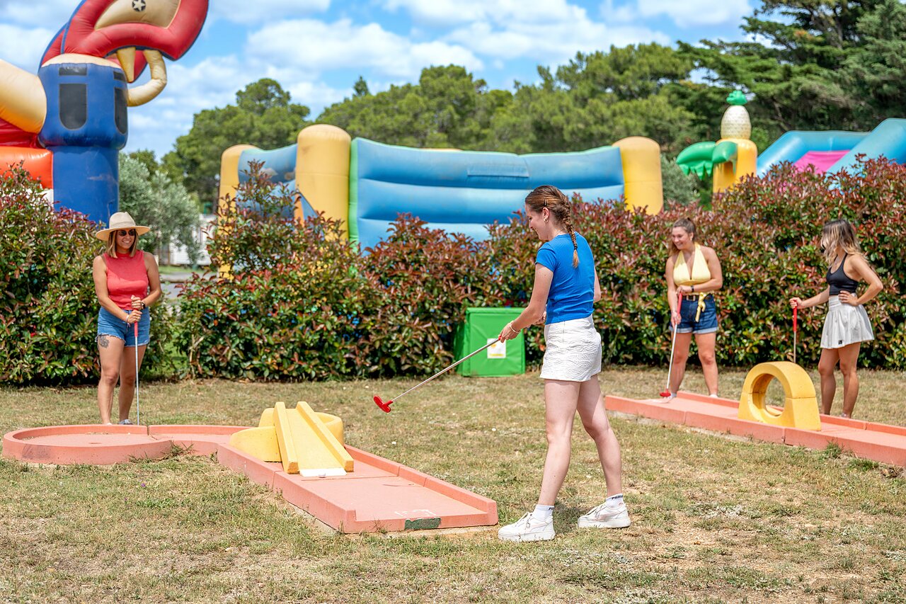 Mujeres jugando minigolf con juegos inflables en el camping CAPFUN Vignes d'Or en Serignan.