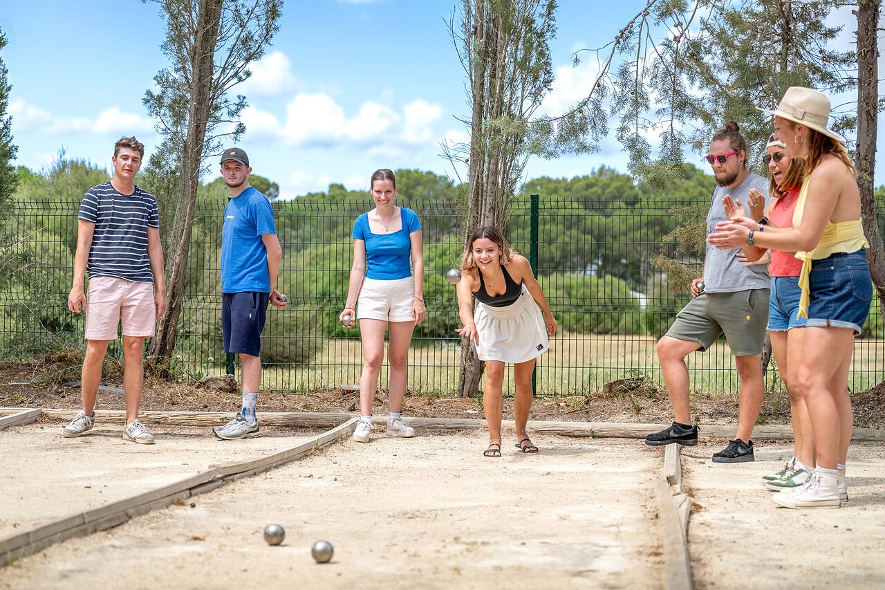 Amigos jugando a la petanca en pista en camping CAPFUN Vignes d'Or en Serignan.