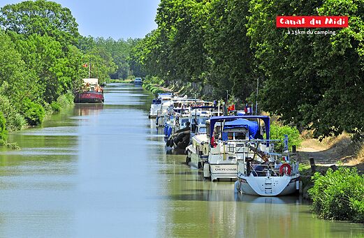 Histórico Canal du Midi con barcos amarrados y árboles verdes en Occitania.