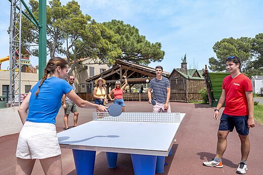 Amigos jugando al tenis de mesa al aire libre en el camping CAPFUN Vignes d'Or en Serignan.