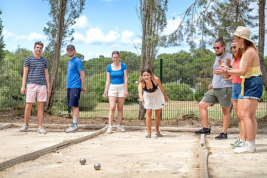 Jóvenes jugando a la petanca en una pista dedicada en el camping CAPFUN Vignes d'Or en Serignan.