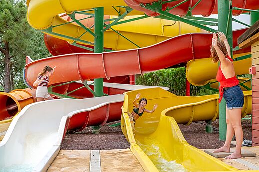 Toboganes acuáticos coloridos y niños divirtiéndose en el camping CAPFUN Vignes d'Or en Serignan.