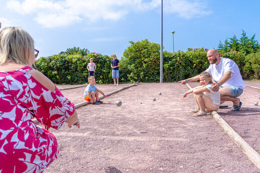 Familia jugando a la petanca en la cancha del camping CAPFUN Vikings en Saint Jean de la Rivi�re (50).