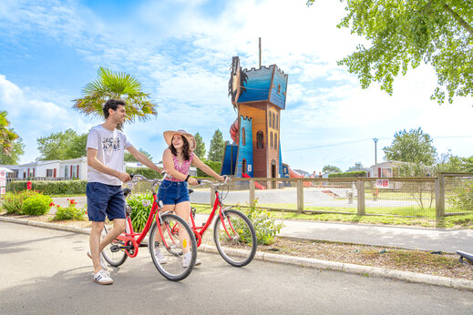 Pareja en bicicleta, torre de juegos infantil en camping CAPFUN Vikings (50).