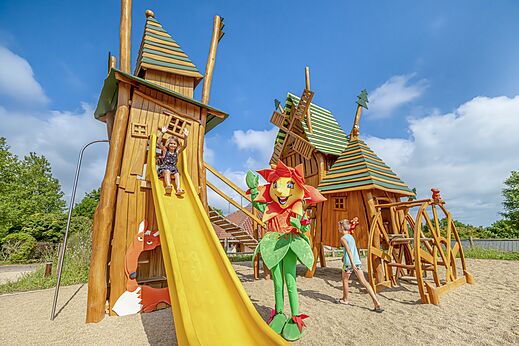 Zona de juegos temática con tobogán y niños en el camping CLICOCHIC Village des Meuniers en Dompierre-les-Ormes (71).