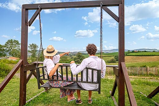 Pareja en columpio disfrutando vista panorámica de la naturaleza en camping CLICOCHIC Village des Meuniers en Dompierre-les-Ormes (71).