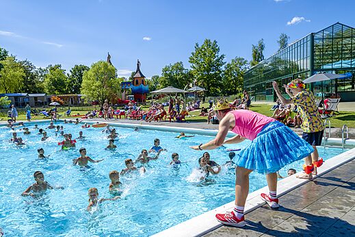 Piscina exterior con animación y niños jugando en el camping CAPFUN Vlinderloo en Enschede.