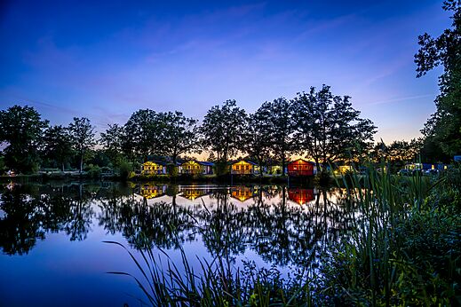 Mobil-homes iluminados junto al lago en el camping CAPFUN Vlinderloo en Enschede.