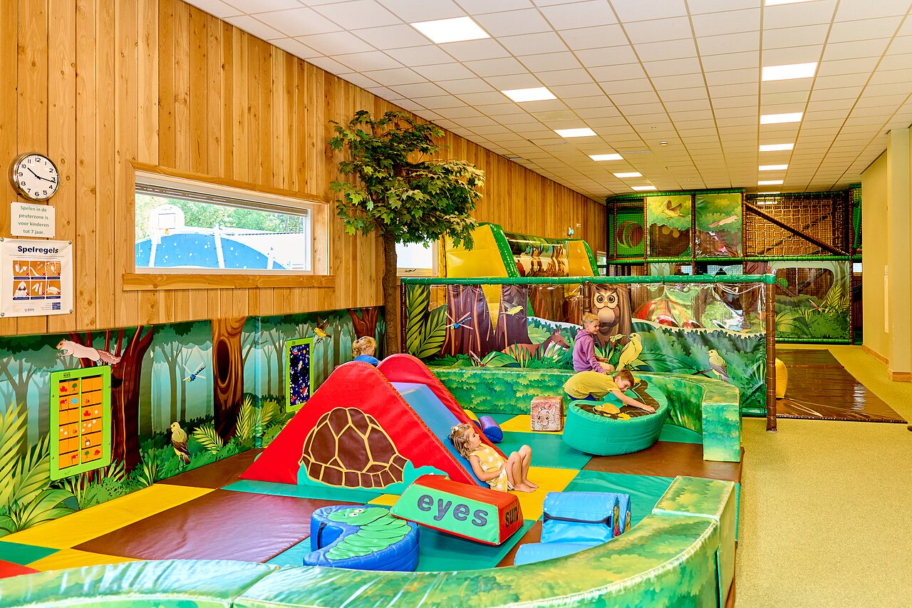 Zona de juegos interior con tobog�n y estructuras para ni�os en CAPFUN De Waldsang.