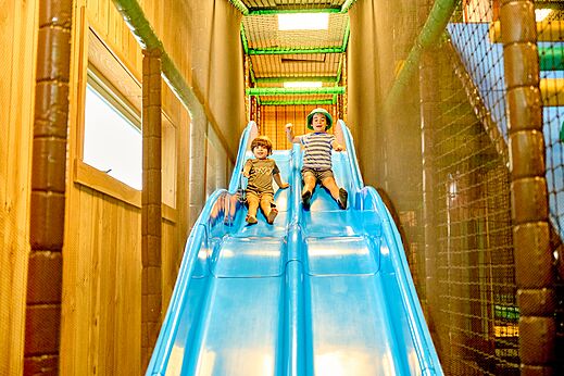Zona de juegos interior con tobogán y niños en el camping CAPFUN De Waldsang en Bakkeveen