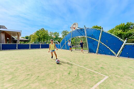 Niños jugando fútbol en la cancha multideportiva del camping CAPFUN De Waldsang en Bakkeveen.