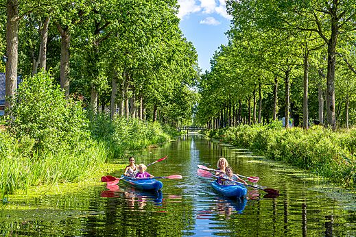 Familias en kayak en un canal verde en el camping CAPFUN De Waldsang en Bakkeveen.