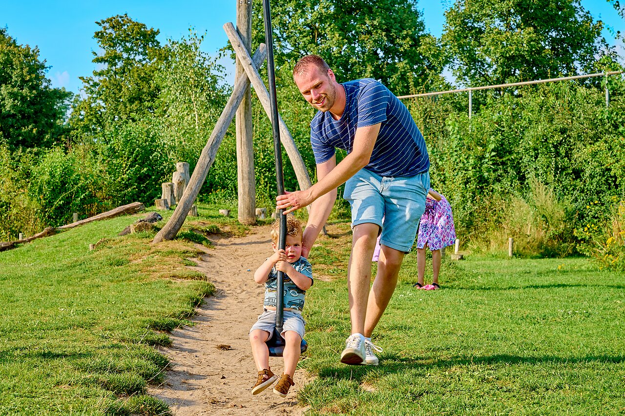 Padre e hijo en tirolina de juegos en el camping CAPFUN Wieskamp en Winterswijk Henxel.