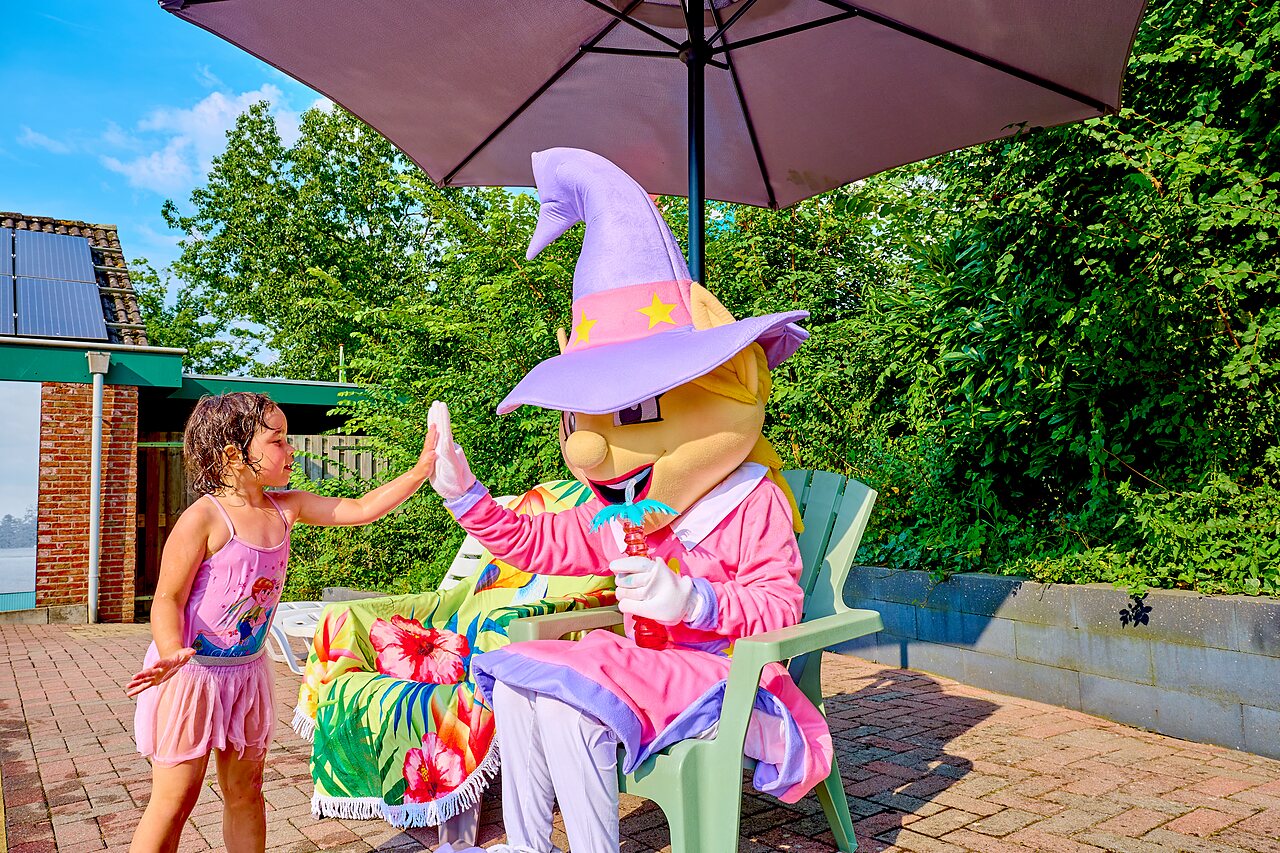 Ni�a y mascota bajo sombrilla en camping CAPFUN Wieskamp, Winterswijk Henxel.