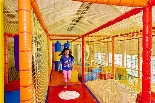 Zona de juegos interior colorida con niña en el camping CAPFUN Wieskamp en Winterswijk Henxel.