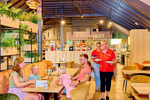 Familia comiendo en el moderno restaurante del camping CAPFUN Wieskamp en Winterswijk Henxel.