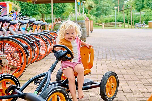 Niño en kart a pedales, bicicletas en el camping CAPFUN Wieskamp en Winterswijk Henxel.