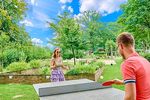 Pareja jugando al tenis de mesa al aire libre en el camping CAPFUN Wieskamp en Winterswijk Henxel.