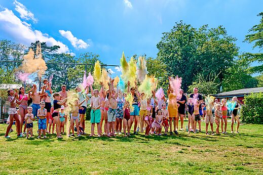 Niños y adultos en animación con polvos de colores en camping CAPFUN Wieskamp en Winterswijk Henxel.