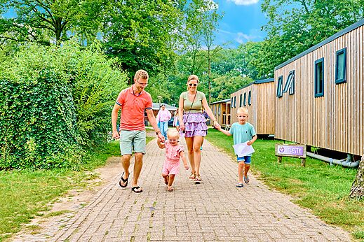 Familia paseando frente a Mobil-homes modernos en el camping CAPFUN Wieskamp en Winterswijk Henxel.