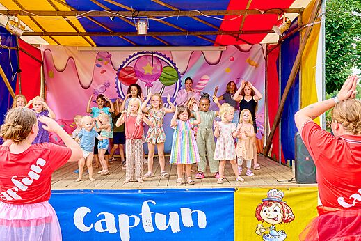Niños participando en animación en escenario con animadores en el camping CAPFUN Wieskamp en Winterswijk Henxel.