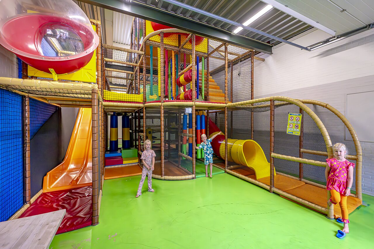 Zona de juegos interior colorida con toboganes para ni�os en el camping CAPFUN het Winkel en Winterswijk.