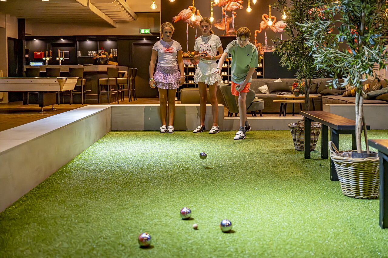 Ni�os jugando a la petanca en pista cubierta en el camping CAPFUN het Winkel en Winterswijk.