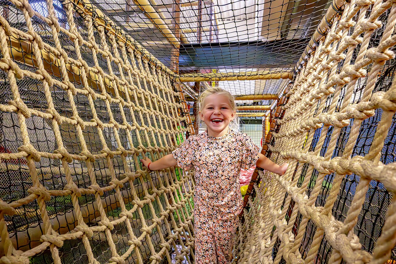 Ni�a sonriente en un puente de cuerdas en el camping CAPFUN het Winkel en Winterswijk.