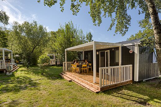 Mobil-home moderno con terraza cubierta y familia en el camping CAPFUN het Winkel en Winterswijk.