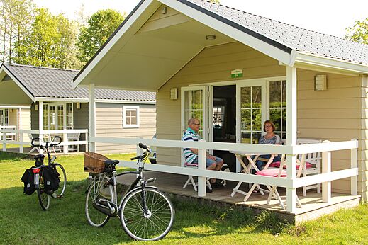 Casa m�vil con pareja en terraza, bicicletas, en el camping CAPFUN het Winkel en Winterswijk.
