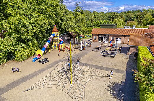 Gran zona de juegos con toboganes y red de escalada en el camping CAPFUN het Winkel en Winterswijk.