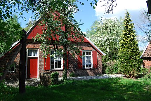Casa tradicional de ladrillo, persianas rojas, jard�n florido en el camping CAPFUN het Winkel en Winterswijk.