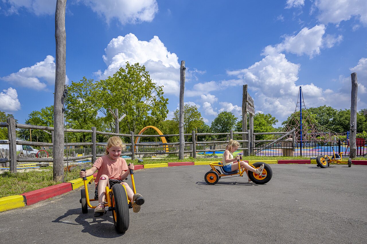 Dos ni�os en karts a pedales en una pista en el camping CAPFUN de Wondermolen en Molenschot.