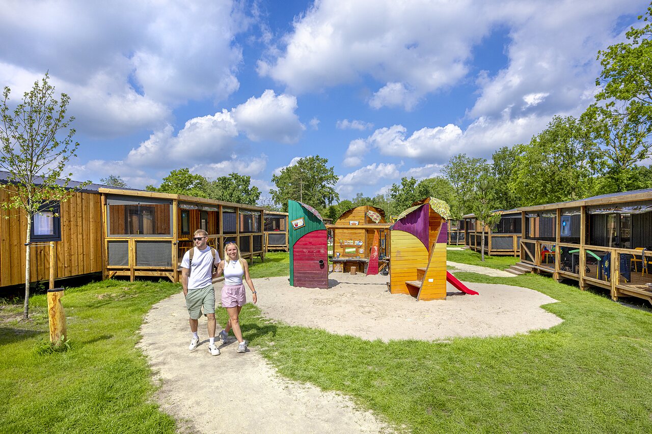 Caba�as de madera y parque infantil colorido en el camping CAPFUN de Wondermolen en Molenschot.